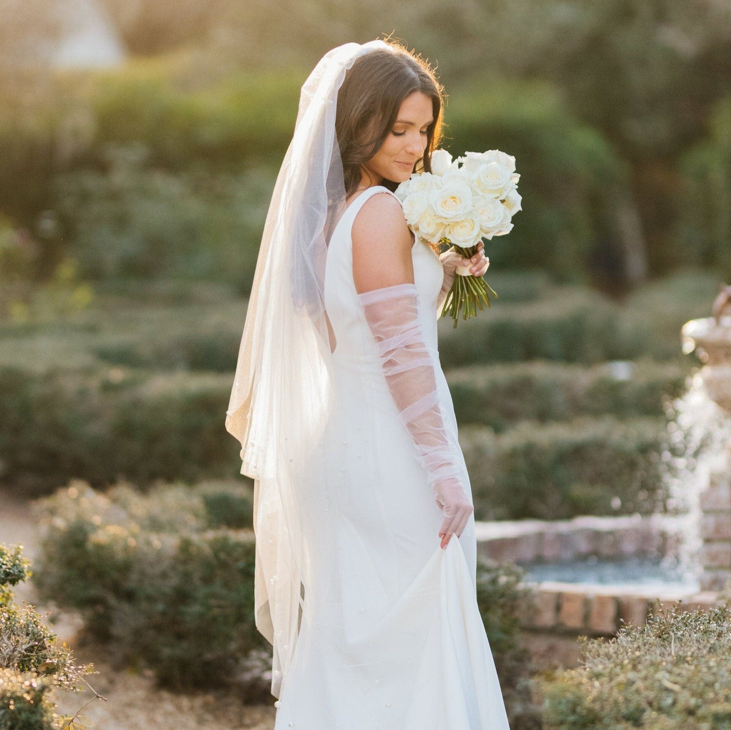 stunning bride in tulle gloves and simple fingertip veil and white bouquet
