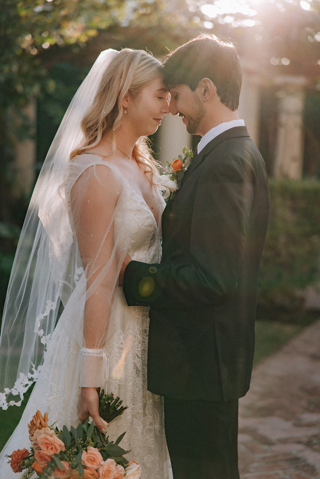 sheer tulle wedding sleeves and ivory vine and leaf fingertip bridal veil and peach wedding bouquet