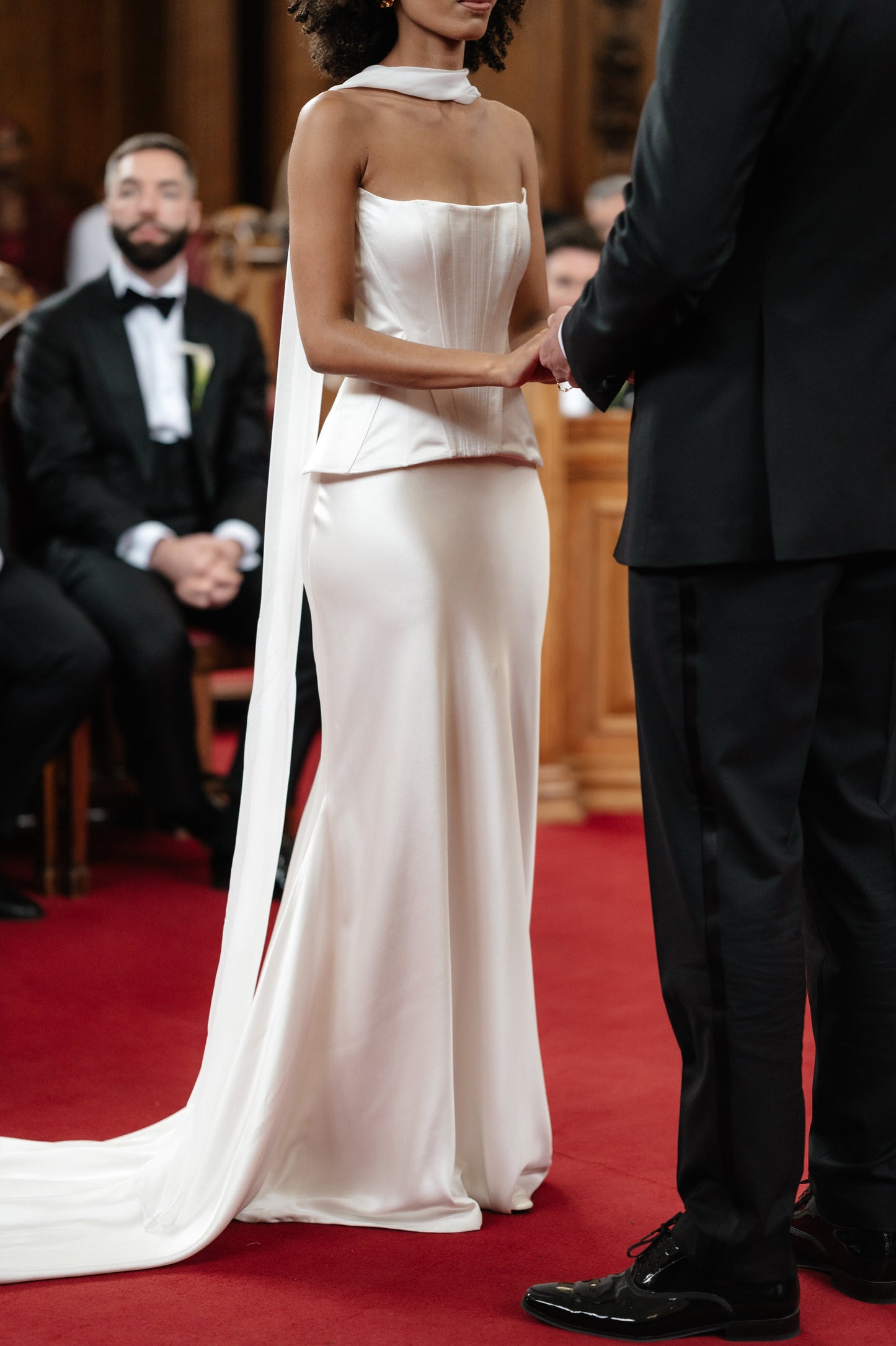 bride in strapless corset and narrow silk satin bridal scarf draped over neck and back 