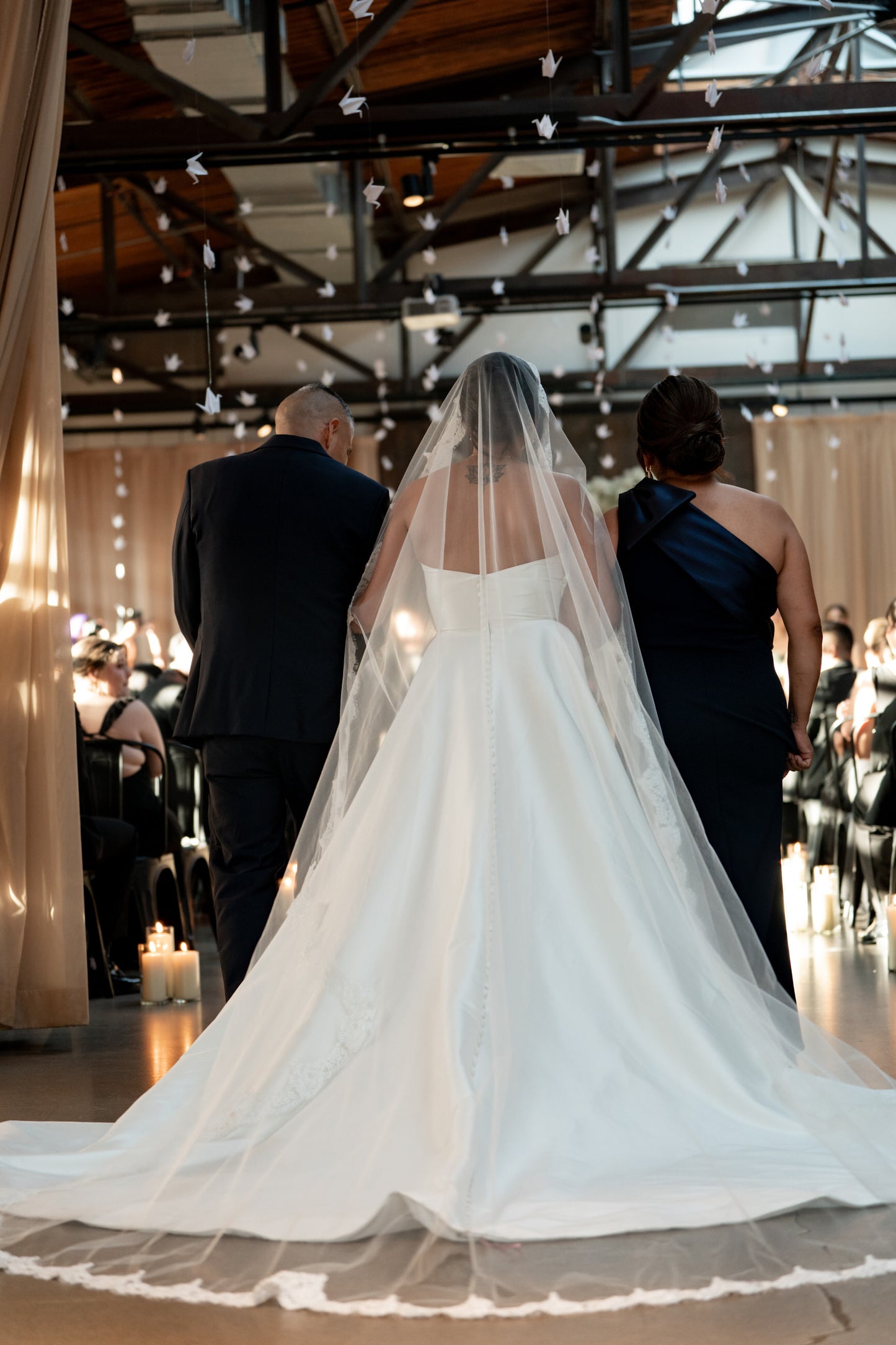 bride wearing a long bridal veil mantilla style over updo for indoor industrial wedding