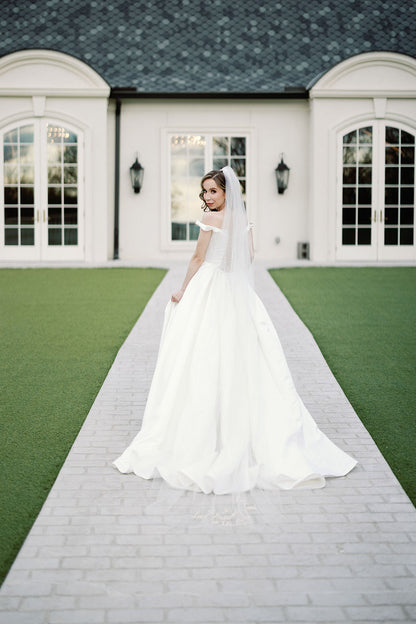 estate wedding with long embroidered wedding veil saying love is patient, love is kind